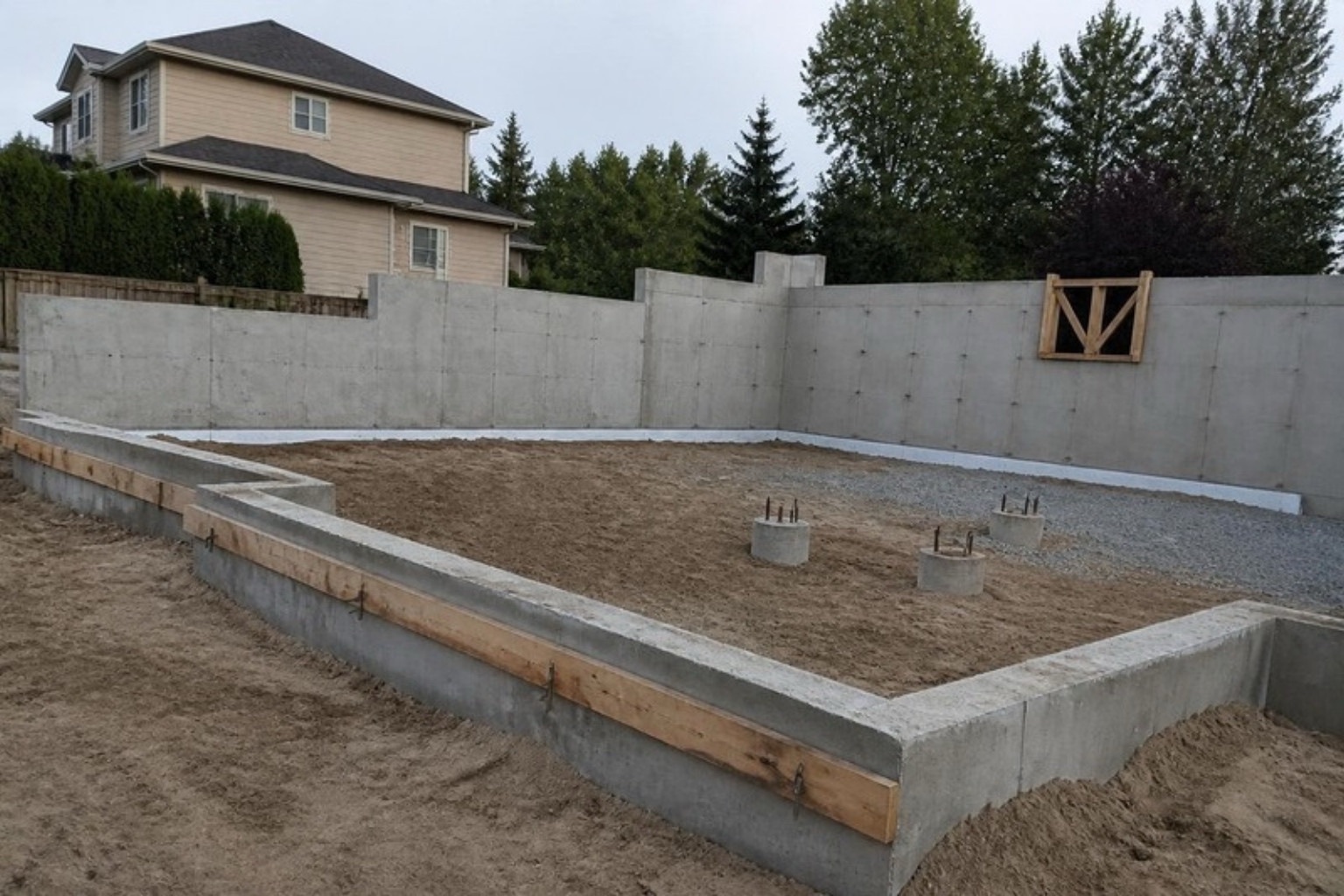 Stripped concrete basement walls, stem wall and pier footings on a residential lot